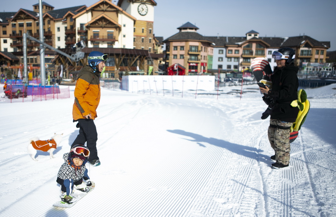 11月18日，一名雪友给正在滑雪的萌宝王予玑拍照。新华社记者 杨世尧 摄
