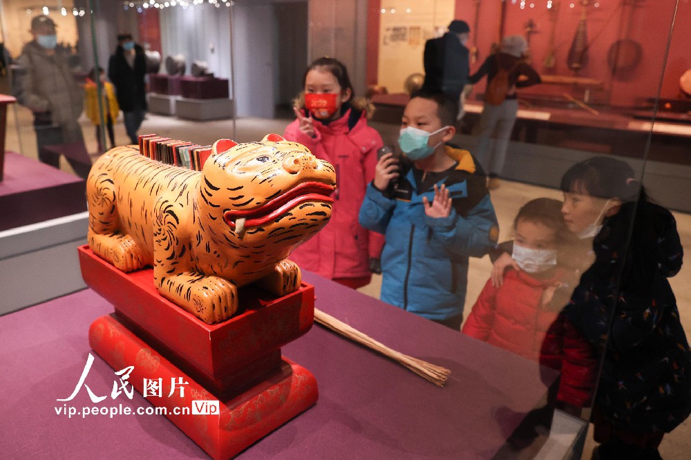 2月9日，孩子们观赏清代形如伏虎的体鸣刮奏乐器“敔”。