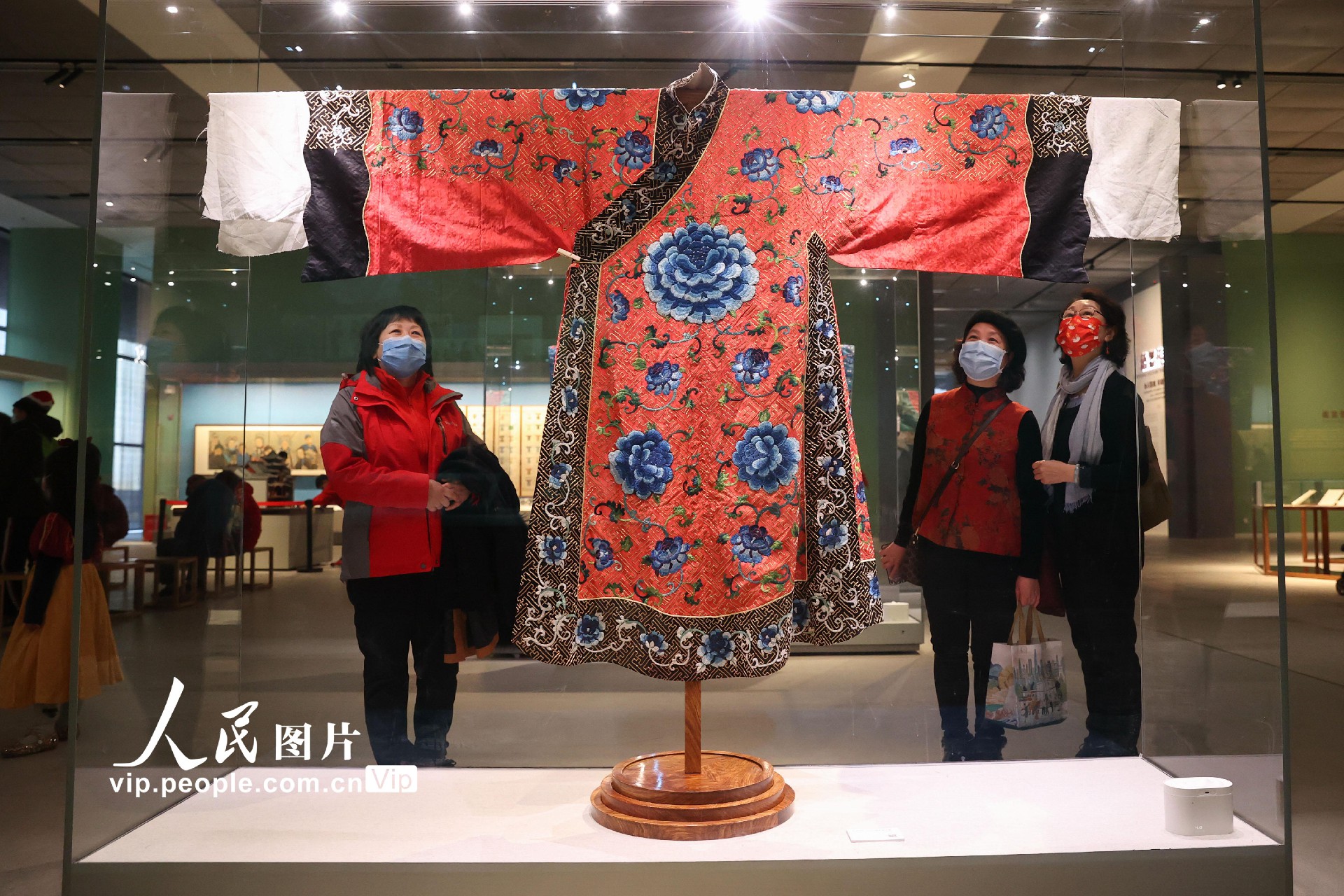 2月9日，观众观赏清代“红绸绣平金回纹地蓝花开氅”。