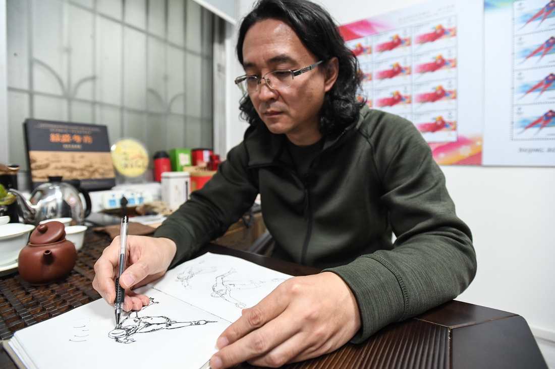 设计师张强展示他设计的北京2022年冬奥会冰上运动纪念邮票的手稿（2月8日摄）。