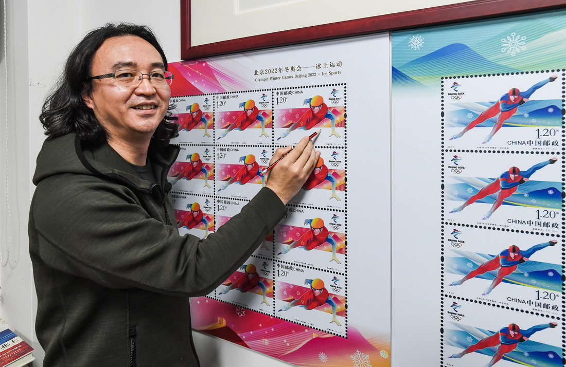 设计师张强展示他设计北京2022年冬奥会冰上运动纪念邮票的创意和设计过程（2月8日摄）。
