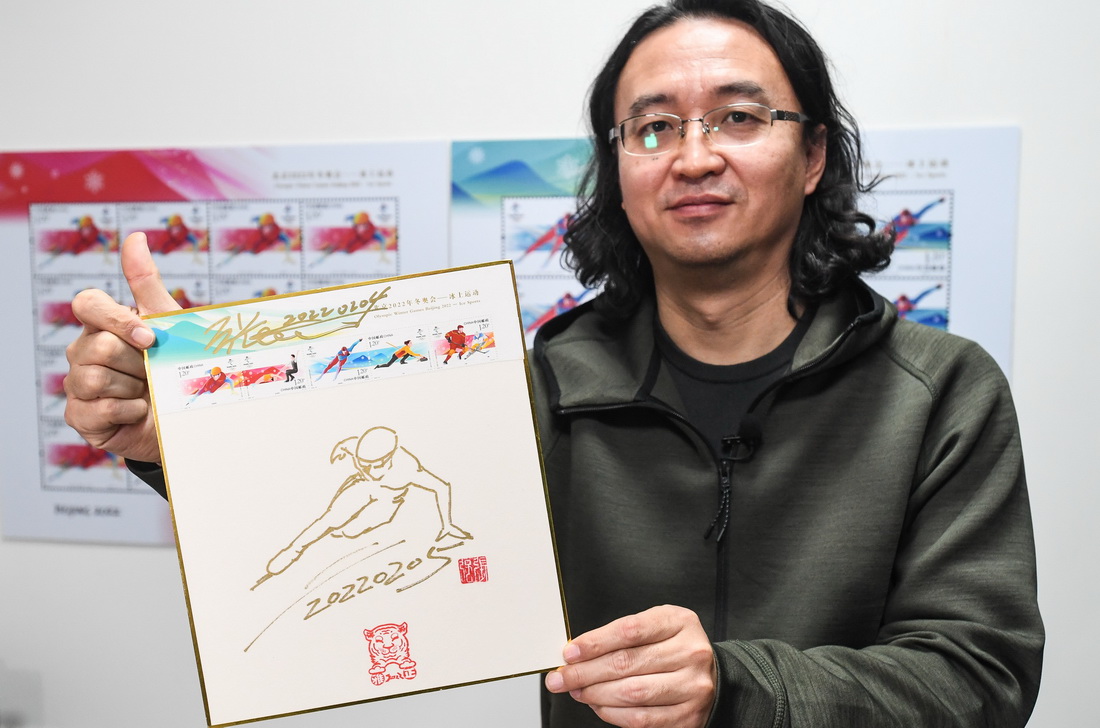 设计师张强展示以他设计的冰上运动纪念邮票画面制作的纪念卡（2月8日摄）。