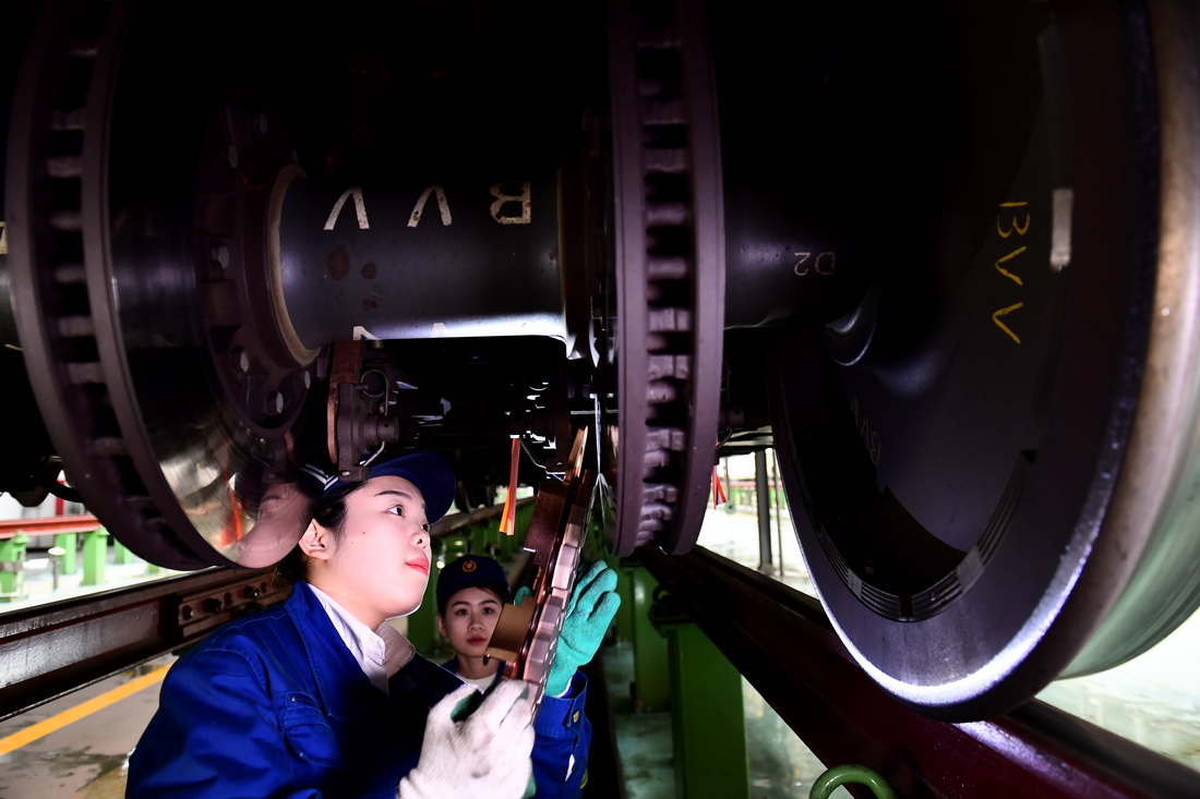 2月10日，在国铁济南局青岛动车段济南动车所，“动车女医生”吕瑞杰在更换动车组制动闸片。