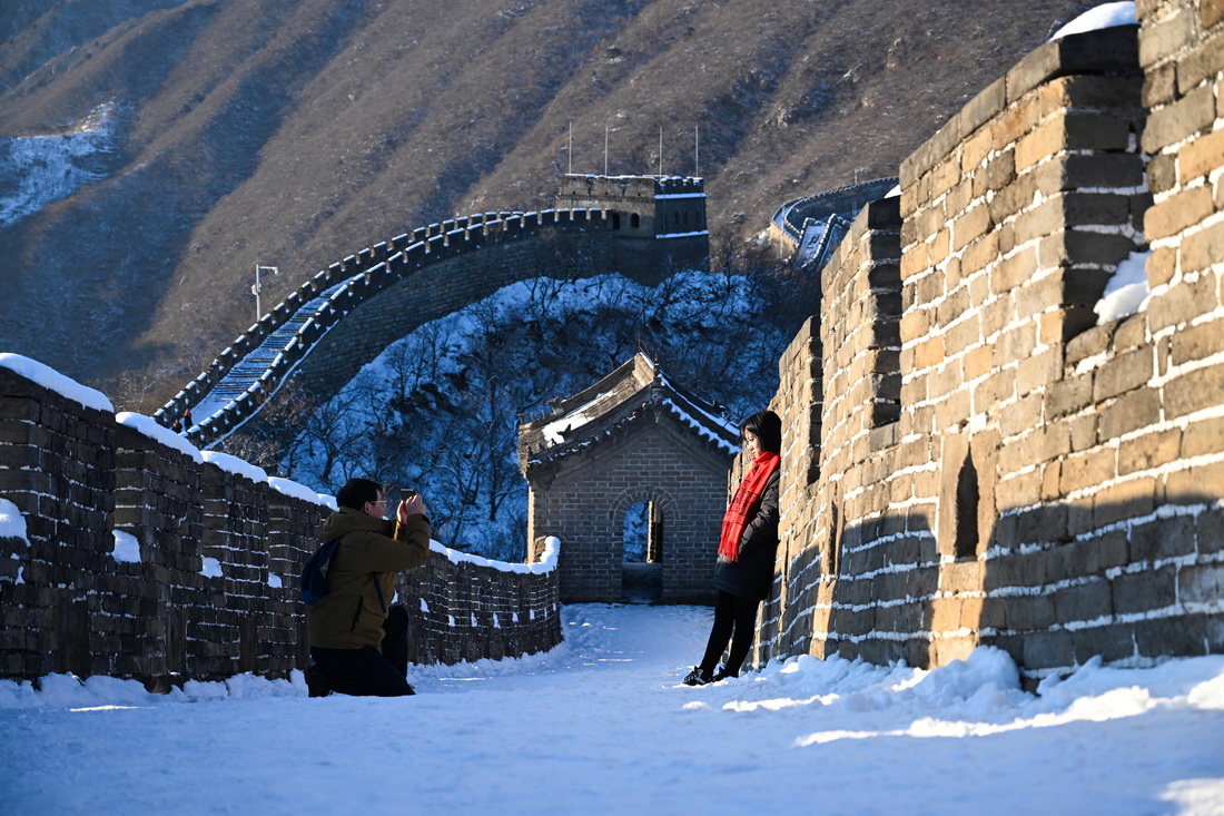 游客在白雪覆盖的慕田峪长城拍照留影（2月14日摄）。